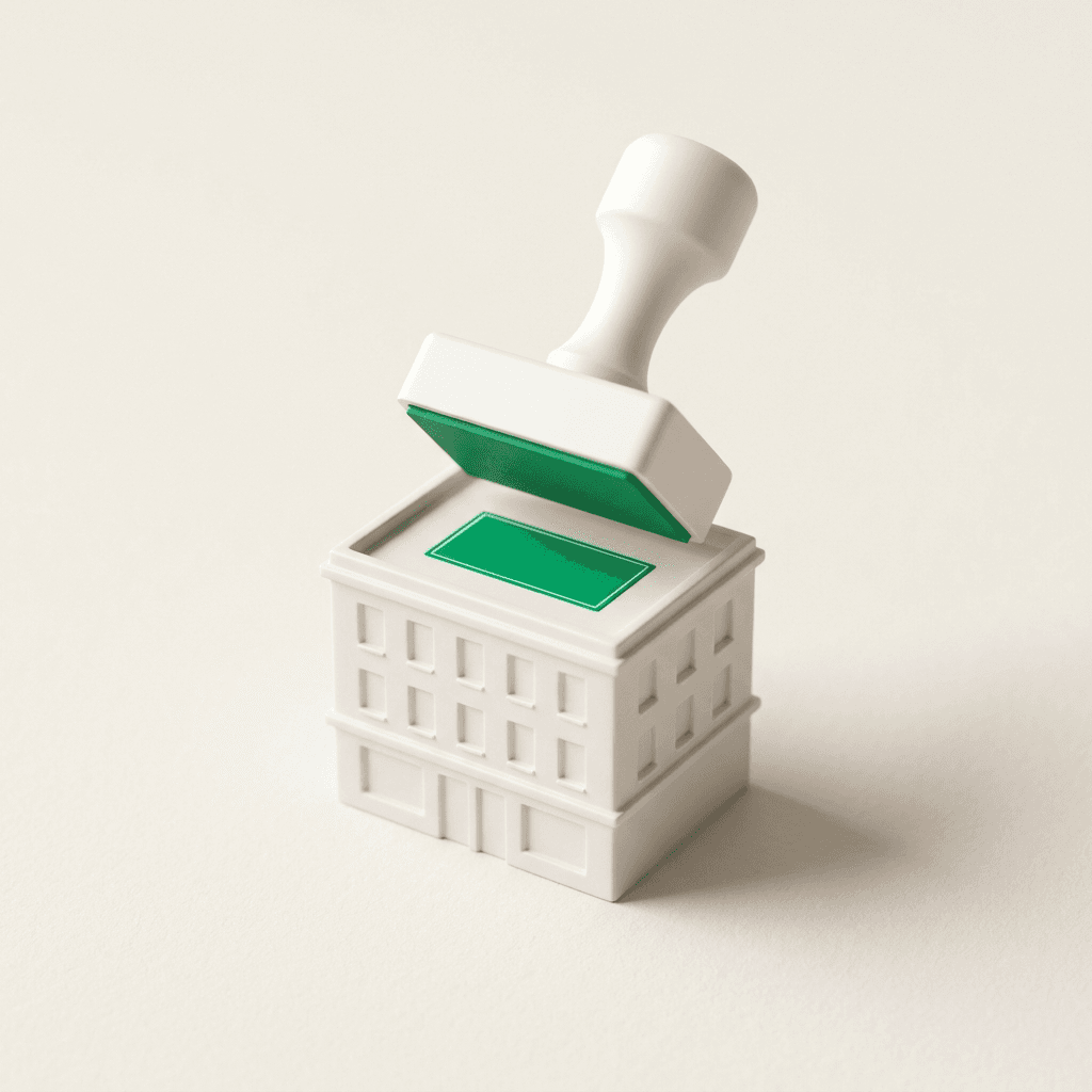 A single white model building with an oversized stamp pressing a green price tag onto it