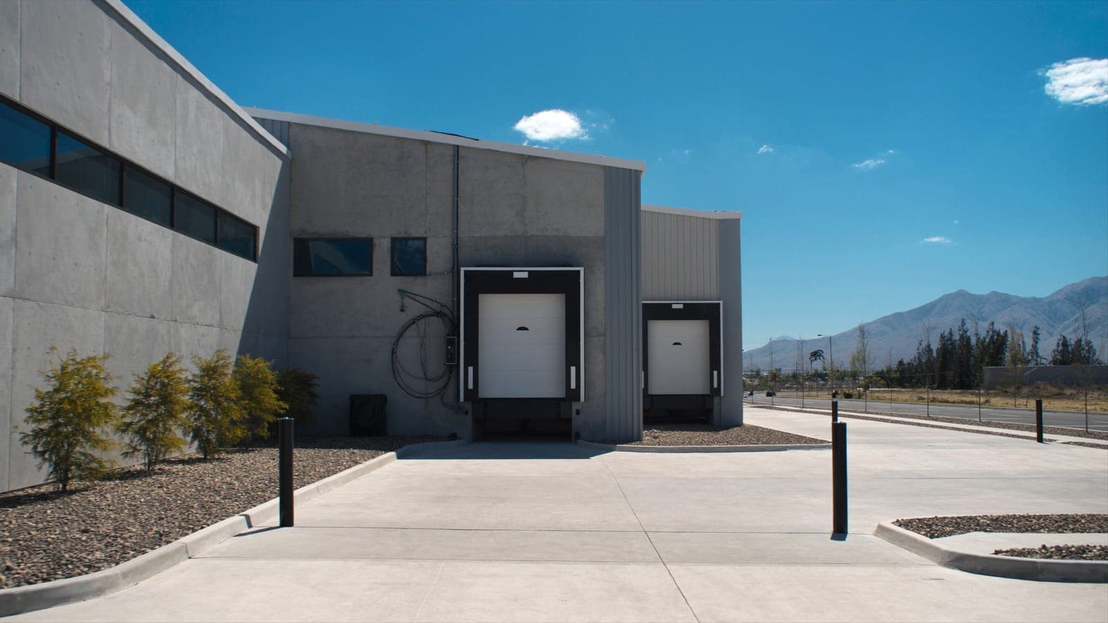 A concrete tilt-up business park under a blue sky with mountains on the horizon