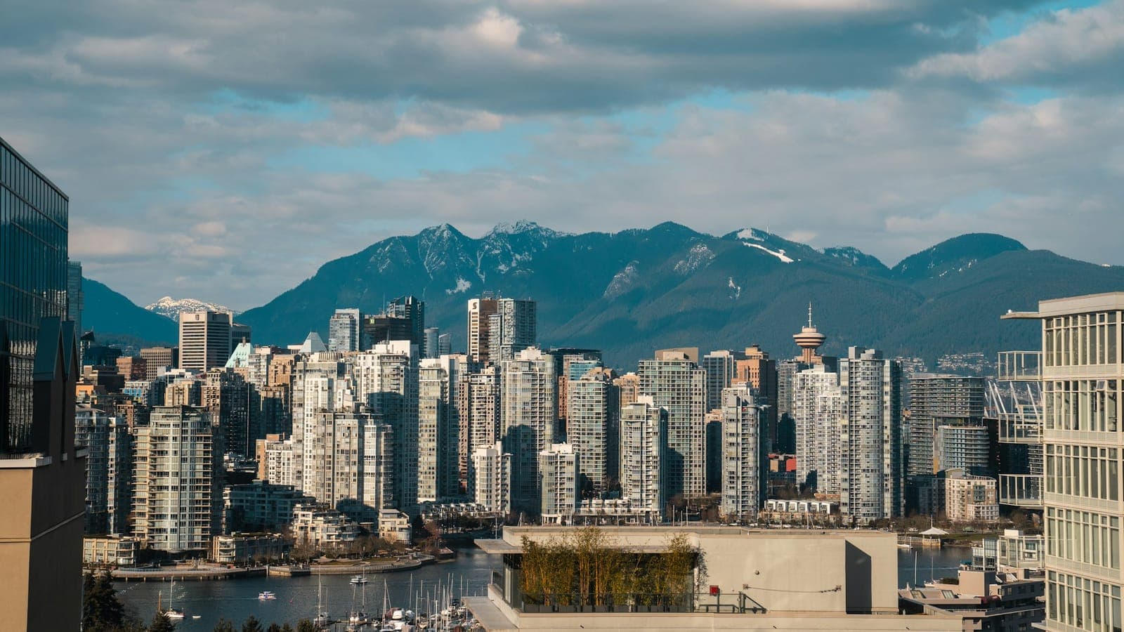 Downtown Vancouver towers and snow-capped mountains above the False Creek marina